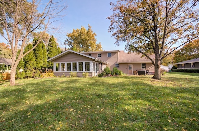 back of house with a lawn and a sunroom