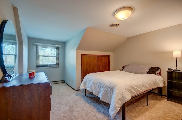 carpeted bedroom with a baseboard heating unit and vaulted ceiling