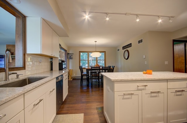 kitchen featuring sink, dark hardwood / wood-style flooring, white cabinetry, decorative light fixtures, and light stone counters