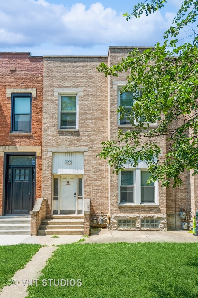 townhome / multi-family property featuring a front lawn