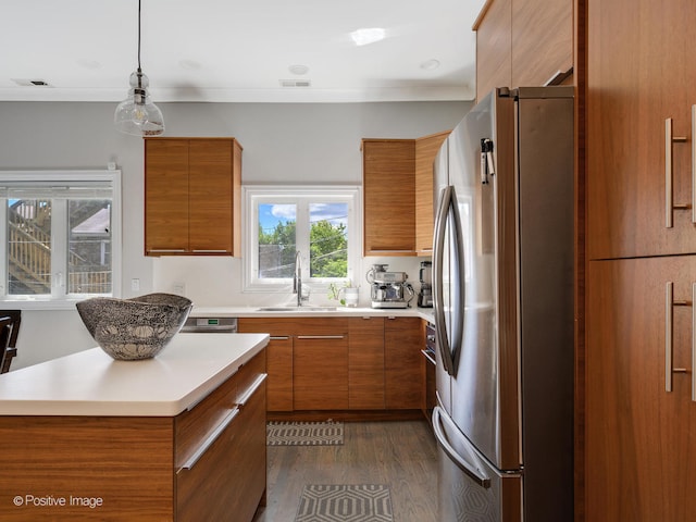 kitchen featuring dark hardwood / wood-style flooring, pendant lighting, sink, and stainless steel refrigerator