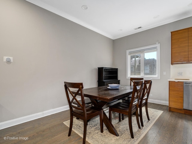 dining room featuring dark wood-type flooring and crown molding