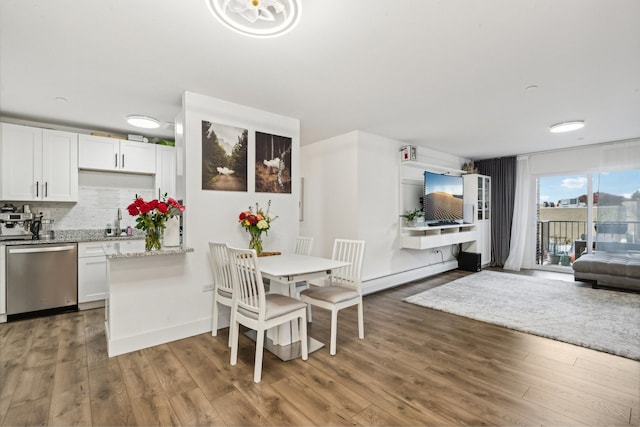 dining space with dark wood-type flooring and a baseboard heating unit