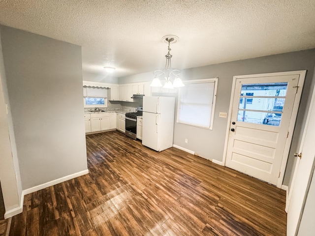 kitchen with decorative light fixtures, white cabinetry, white refrigerator, gas stove, and dark wood-type flooring