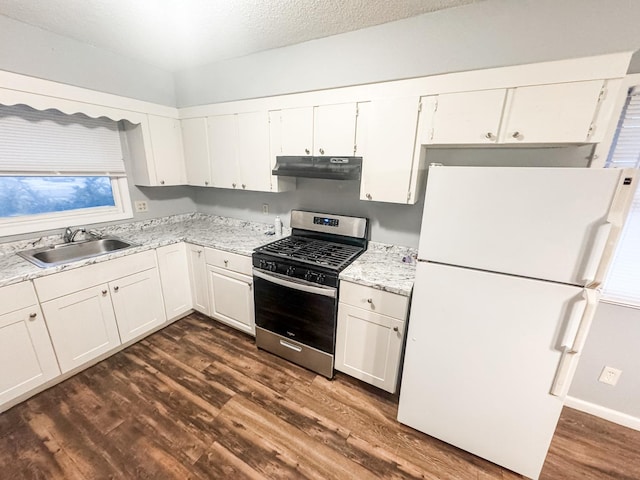 kitchen featuring white refrigerator, stainless steel gas range, sink, and white cabinets