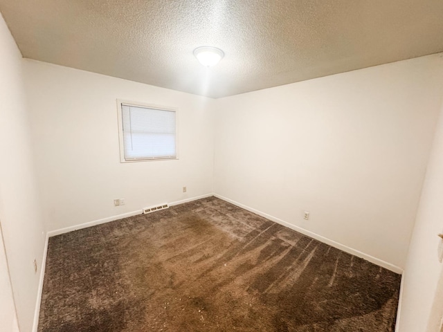 carpeted spare room featuring a textured ceiling