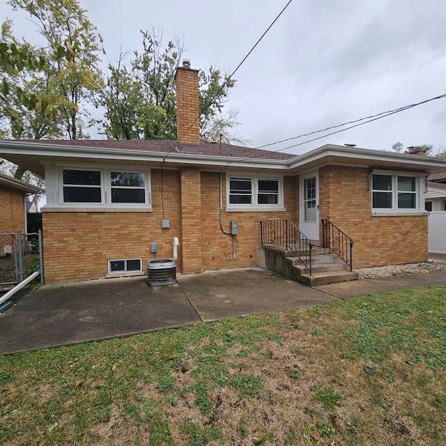 back of property with a patio area, a yard, and cooling unit