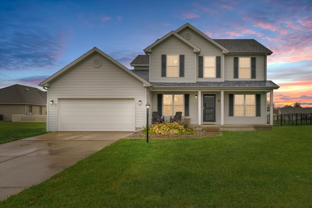 view of front of house with a garage, a yard, and a porch