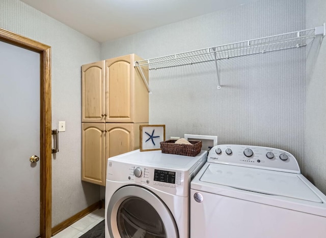 clothes washing area with cabinets and separate washer and dryer