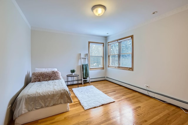 bedroom with ornamental molding, light wood-type flooring, and baseboard heating