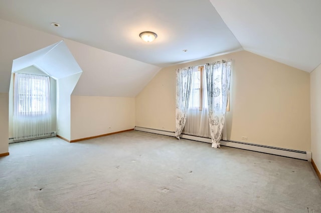 bonus room featuring a baseboard radiator, a healthy amount of sunlight, and vaulted ceiling