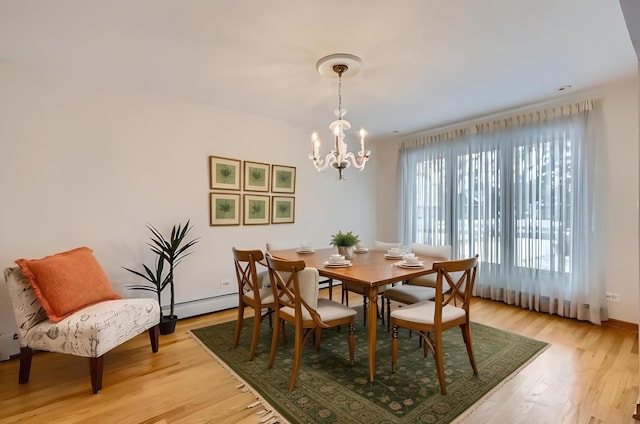 dining room featuring baseboard heating, a chandelier, and light wood-type flooring