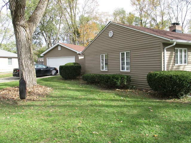 view of side of home featuring a yard and a garage