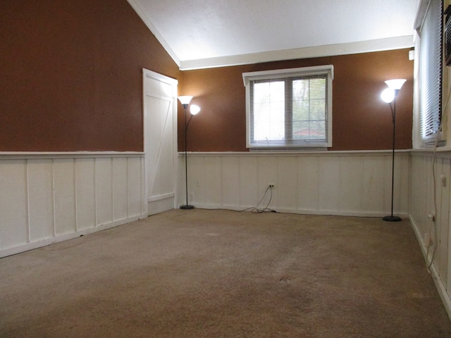 carpeted spare room featuring lofted ceiling