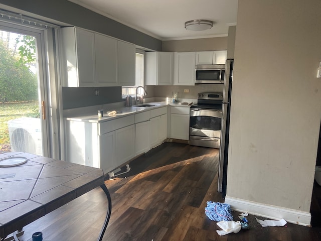 kitchen with stainless steel appliances, dark hardwood / wood-style floors, sink, white cabinets, and tile countertops