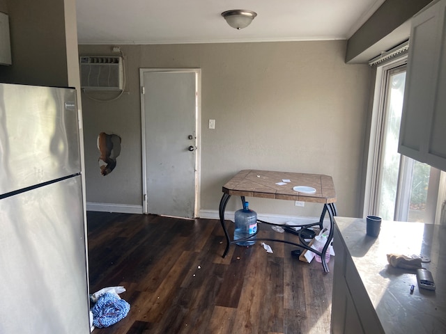 interior space with dark wood-type flooring, a wall mounted AC, and ornamental molding