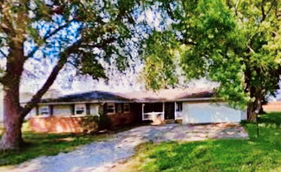 single story home featuring a garage and a front lawn