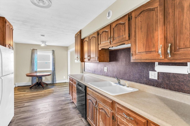 kitchen with sink, black dishwasher, white refrigerator, and decorative backsplash