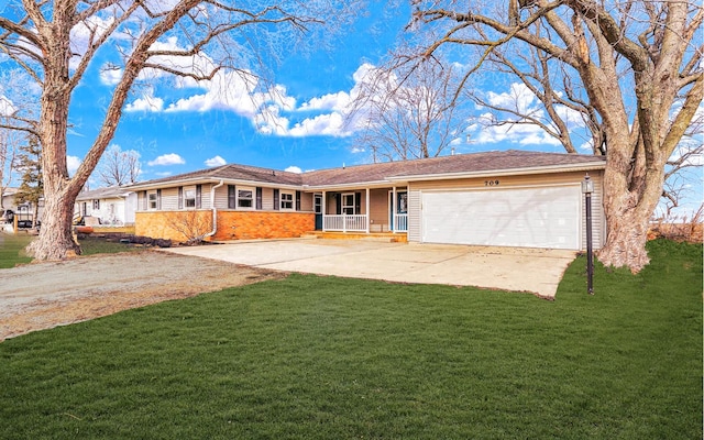 ranch-style home featuring covered porch, a front yard, and a garage