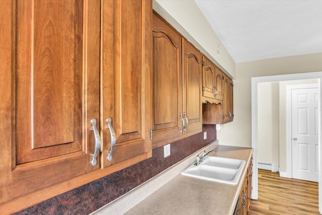 kitchen featuring sink, light wood-type flooring, and baseboard heating