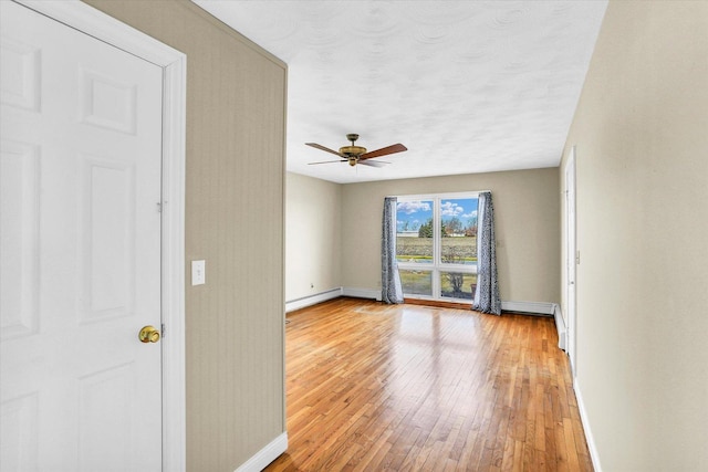 empty room with light wood-type flooring and ceiling fan