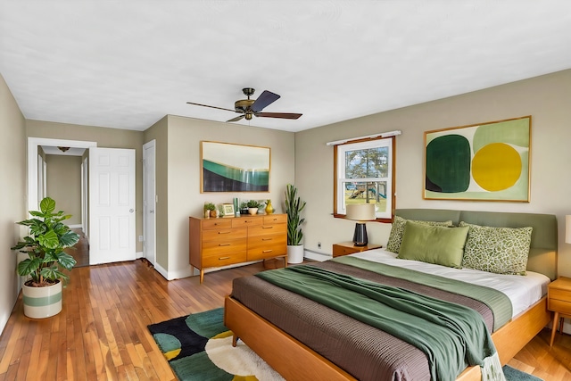 bedroom with hardwood / wood-style flooring, ceiling fan, and baseboard heating