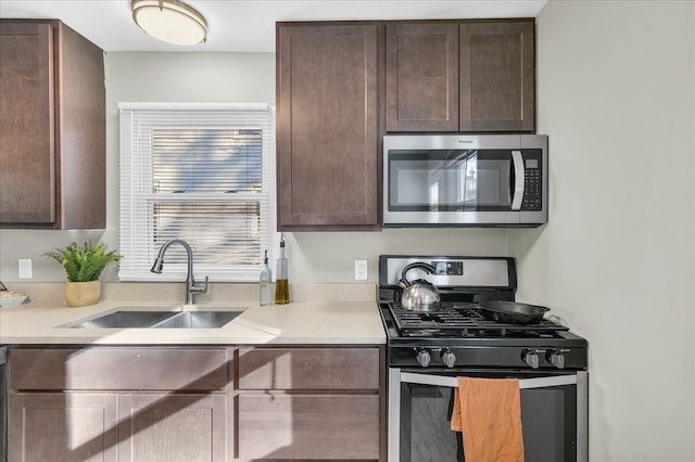 kitchen with dark brown cabinetry, sink, and appliances with stainless steel finishes