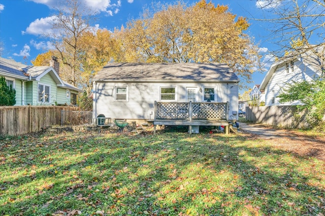 rear view of property with a yard and a deck