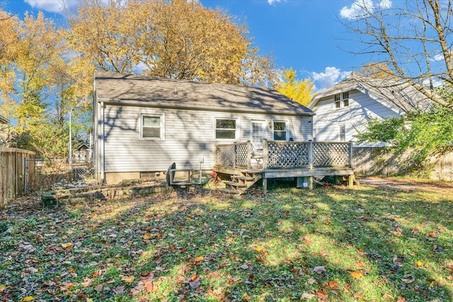 back of house featuring a lawn and a deck