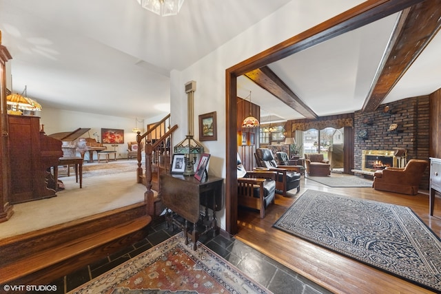 interior space featuring beamed ceiling, dark wood-type flooring, and a brick fireplace