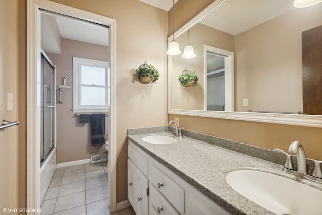 full bathroom with tile patterned flooring, vanity, combined bath / shower with glass door, and toilet