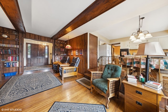 entrance foyer with wooden walls, light hardwood / wood-style flooring, beamed ceiling, and an inviting chandelier