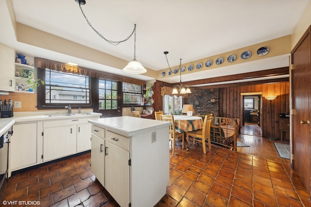 kitchen featuring white cabinets, sink, decorative light fixtures, a kitchen island, and dark hardwood / wood-style flooring