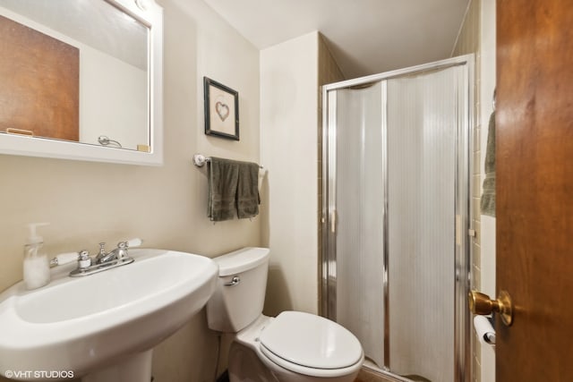 bathroom with toilet, an enclosed shower, and sink