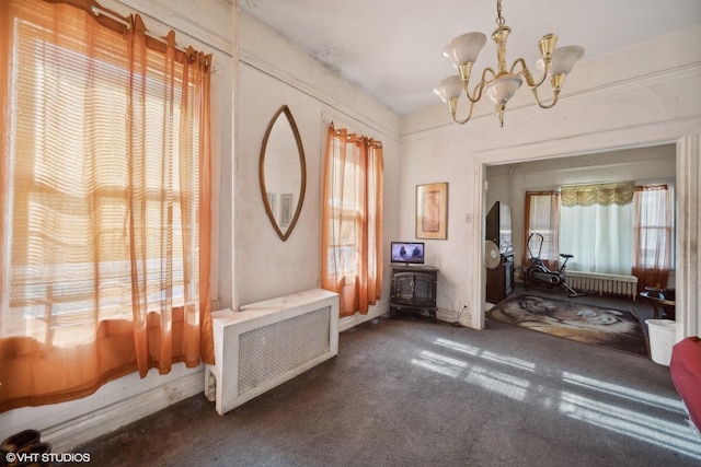 7505 S Emerald Ave, Chicago, IL 60620 - living room featuring a wood stove, dark colored carpet, a chandelier, radiator, and radiator heating unit