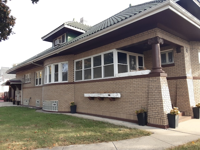 view of side of property with a lawn and cooling unit