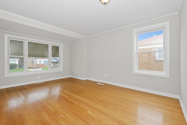 empty room featuring crown molding and light wood-type flooring