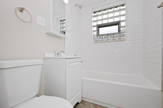 full bathroom featuring tiled shower / bath, vanity, and toilet