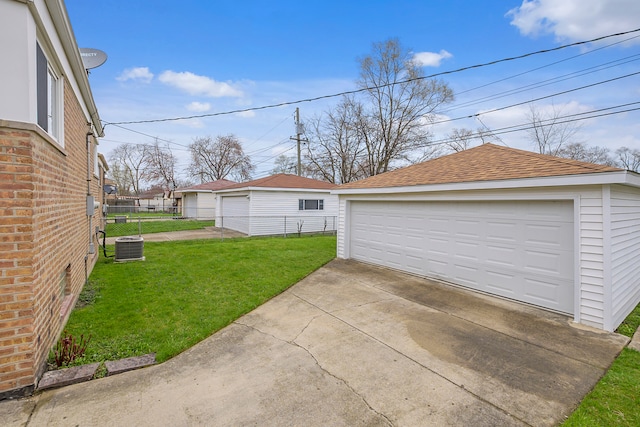 garage with a yard and central AC unit