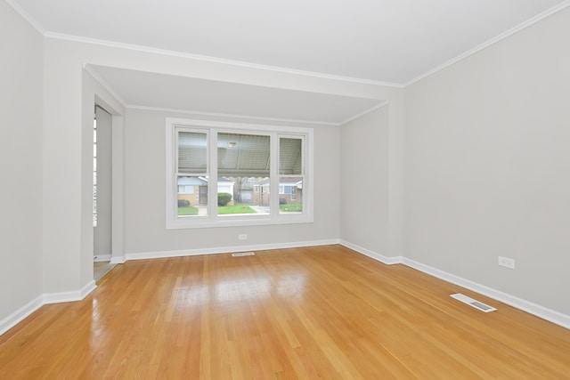 unfurnished room featuring ornamental molding and light wood-type flooring