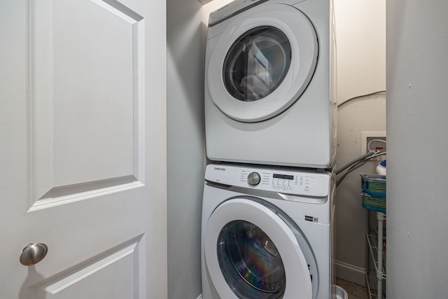 clothes washing area with stacked washer / dryer