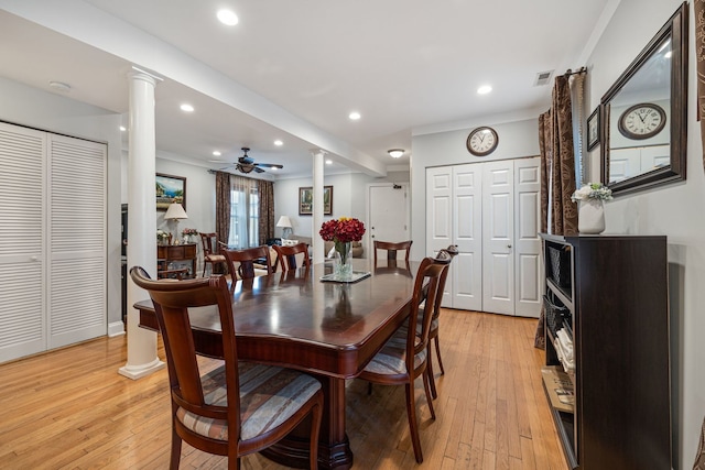 dining area with ceiling fan, light hardwood / wood-style floors, ornate columns, and crown molding