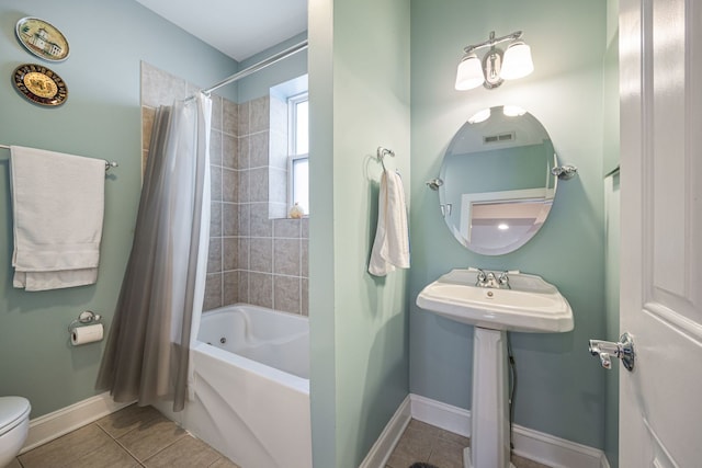 bathroom featuring shower / tub combo with curtain, tile patterned flooring, and toilet