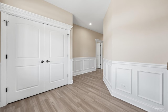 interior space featuring a decorative wall, recessed lighting, and light wood-type flooring