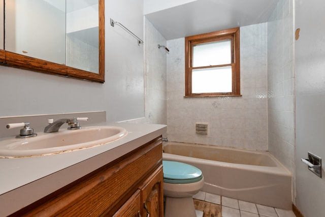 full bathroom featuring tile patterned flooring, vanity, toilet, and tiled shower / bath