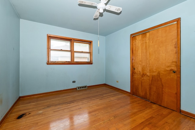 unfurnished bedroom featuring a closet, light hardwood / wood-style flooring, and ceiling fan