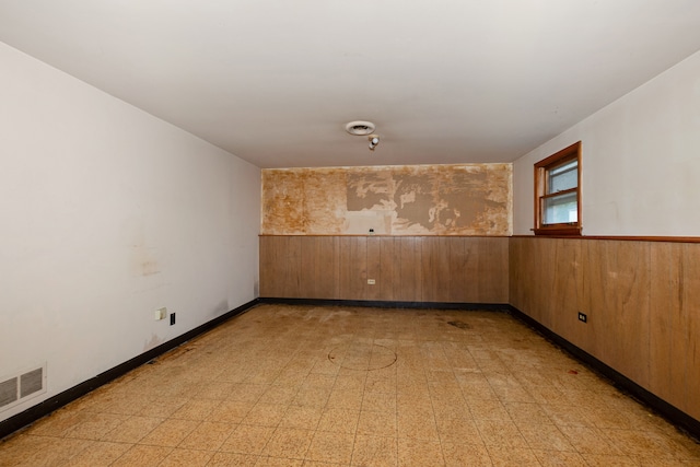 unfurnished room with wood walls