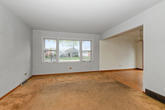 unfurnished room with hardwood / wood-style floors and an inviting chandelier