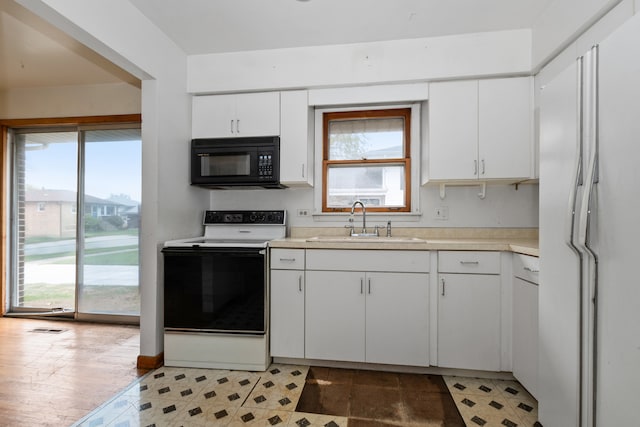 kitchen featuring white cabinetry, sink, and white appliances