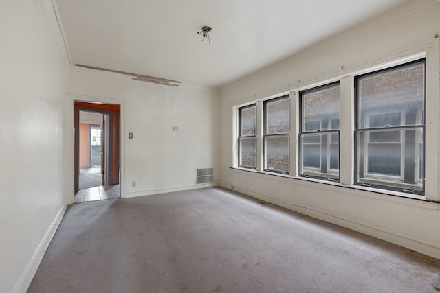 carpeted spare room featuring crown molding